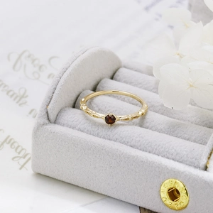 Detail of red garnet ring in gold-plated S925 silver with elegant beaded texture