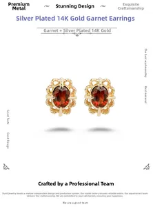 Detailed macro view of retro lace hollow 14K gold plated silver earrings with red garnet