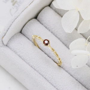 Macro detail of natural garnet ring with gold-plated S925 silver vintage beaded band