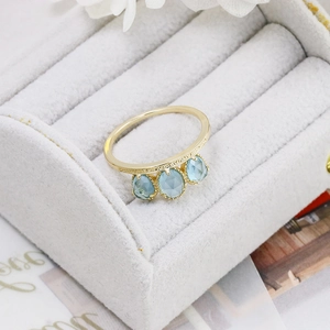 Close-up of vintage s925 silver gold-plated ring with three light blue oval gemstones