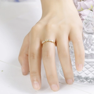 Detalle de un anillo dorado con cinco piedras preciosas de colores lucido por una modelo