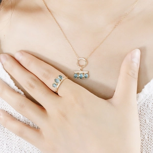 Detail of s925 silver gold-plated necklace and ring with blue rose cut gemstones