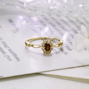 Macro detail of garnet ring with ornate gold lace setting and hollow-out craftsmanship