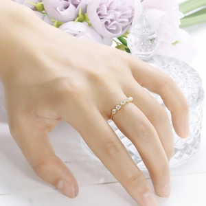 Elegante anillo de oro con ópalo colorido y piedras preciosas en la mano de mujer