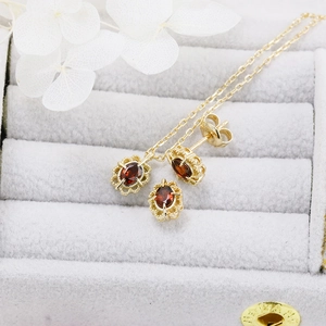 Detailed close-up of retro lace gold garnet jewelry set including necklace and earrings