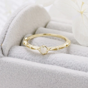 Macro shot of S925 gold-plated ring with white gemstone in gray velvet jewelry box