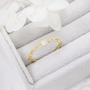 Detail of s925 silver gold-plated ring with round moonstone and braided band
