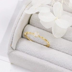Detailed close-up of a gold S925 silver ring with vintage embossing and round moonstone