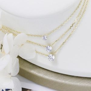Close-up of three 925 silver moissanite necklaces with different diamond sizes on 18K gold chain