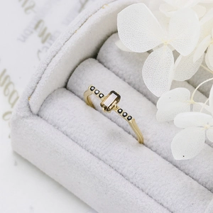 Detailed close-up of octagonal smoky quartz ring in gold setting with black side stones