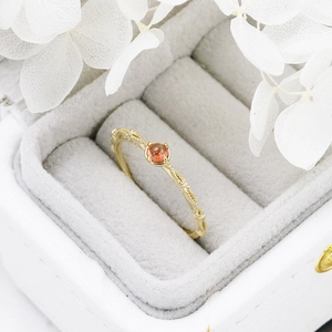 Macro shot of s925 silver gold-plated ring with red garnet and vintage floral engraving