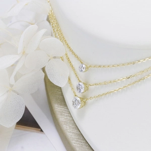 Detailed view of three minimalist 18K gold S925 silver necklaces with round CZ pendants