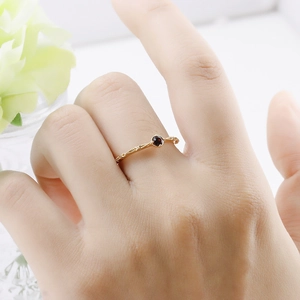 Close-up of vintage gold ring with garnet stone and engraved floral ribbon detail