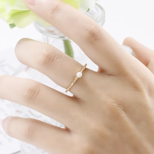 Macro shot of s925 gold-plated silver ring featuring a round white pearl and textured band