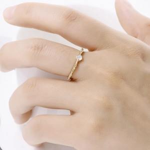 Close-up of a s925 silver gold-plated ring with garnet gemstone on a model's finger