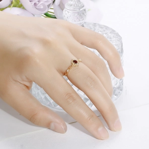 Macro shot of vintage garnet ring with hollow lace engraving and tiny diamonds in gold