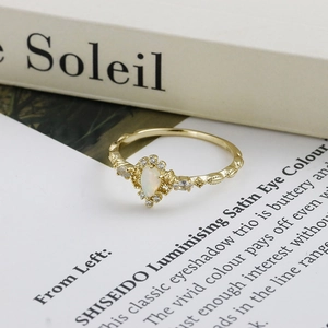 Makroaufnahme von birnenförmigem Opalring mit Vintage-Gravur und Gold-Finish