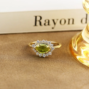 Vista macro dell'anello con quarzo verde taglio marquise e fascia dorata incisa
