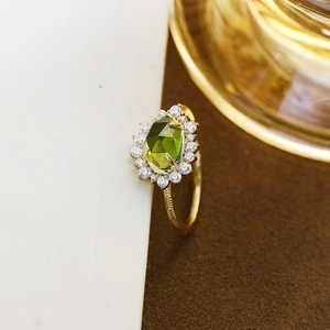 Dettaglio dell'anello in quarzo verde con pietre halo e fascia d'oro incisa