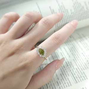 Dettaglio di un anello vintage con pietra marquise verde e fascia in argento placcato oro