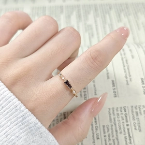 Nahaufnahme eines Vintage Goldrings mit lila Edelstein und Perlen auf Zeitungshintergrund