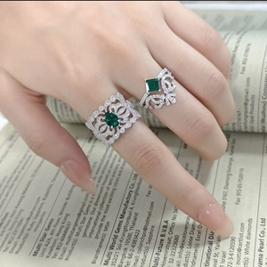 Gros plan d'une bague couronne en argent et bague émeraude sur la main d'un mannequin