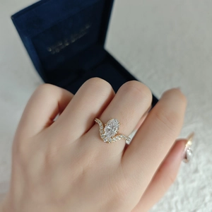 Macro detail of an oval cut diamond ring in gold setting worn on a finger
