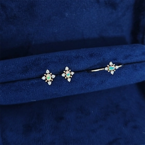 Detailed shot of vintage gold opal ring and stud earrings set in a navy velvet jewelry box