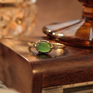 Exquisite S925 gilded silver ring with green chalcedony and side stones on wooden base
