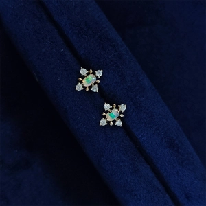 Elegant S925 silver opal snowflake stud earrings with gold finish and blue velvet background