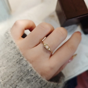 Detailansicht eines vergoldeten S925-Silberrings mit Opal und Perlen am Finger