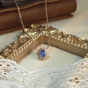 Collier vintage en or avec pierre bleue et pendentif ajouré sur cadre ornementé
