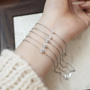 Detailed view of five silver S925 bracelets with sparkling round cut diamonds on wrist