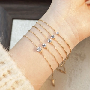 Detailed comparison of five gold chain bracelets with varying diamond sizes on a model wrist