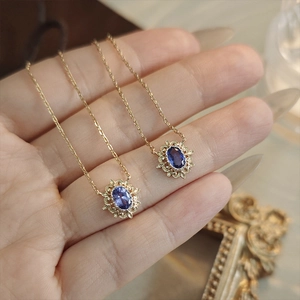 Collier vintage en or avec tanzanite ovale et bordure florale ajourée complexe