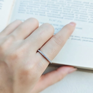 Macro di un sottile anello eternity in argento con pietre luccicanti su un libro