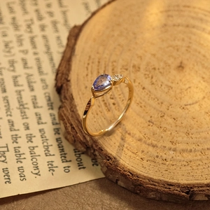 Bague élégante en argent S925 avec tanzanite poire sur un support en bois
