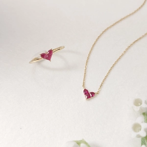 Detailed macro shot of red heart gemstone necklace and S925 silver gold-plated ring set