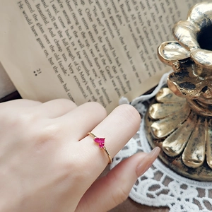 Detailed view of dual pink heart-shaped stones on a slim golden ring band