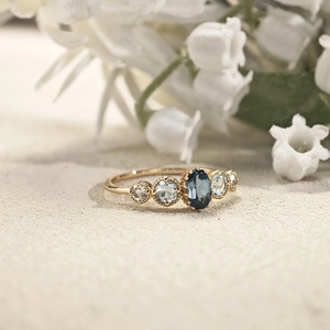Detail of vintage gold ring with oval blue topaz and intricate beaded metalwork