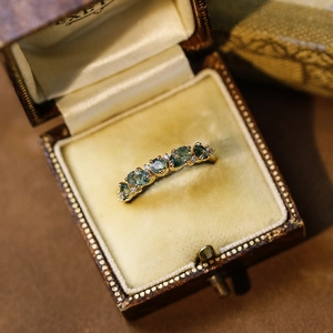 Macro shot of vintage gold moss agate ring with oval green stones in a velvet box