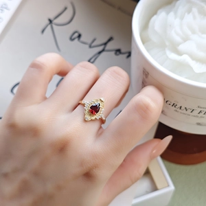 Detailed view of a vintage gold-plated silver ring with red pear-cut garnet on hand
