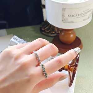 Detail of gold gemstone rings with oval-cut light blue and dark green moss stones