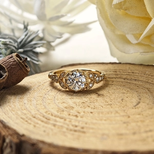 Vue détaillée d'une bague moissanite vintage en or avec détails milgrain sur bois