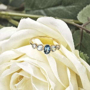 Natural topaz S925 silver gold-plated ring featuring five blue stones on a white rose