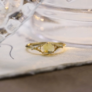 Dettaglio di un anello vintage in oro con citrina ovale e fascia con trama intrecciata