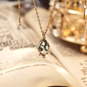 Macro detail of moss agate pendant and earrings set in S925 sterling silver gold plating