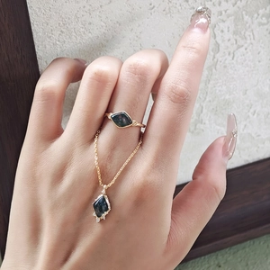 Detailed shot of kite-cut moss agate ring and pendant set in 14K gold plated silver