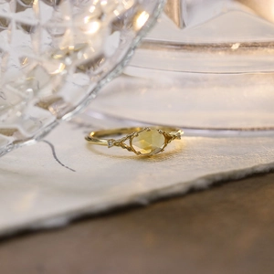 Dettaglio di anello in argento placcato oro con citrino giallo ovale e fascia intrecciata