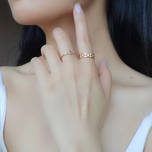 Detail van vergulde opengewerkte ringen met sterpatroon en paarse edelsteen